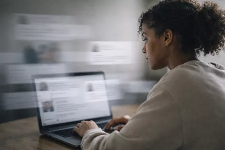 Junge Frau sitzt am Schreibtisch und schaut auf den Laptop mit Social Media Inhalten Content Marketing funktioniert nicht Warum Content nicht funktioniert (auch wenn er gut ist) Textagentur Textineers